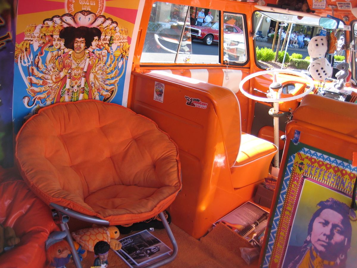 Inside a hippie van with orange decor and a Jimi Hendrix poster