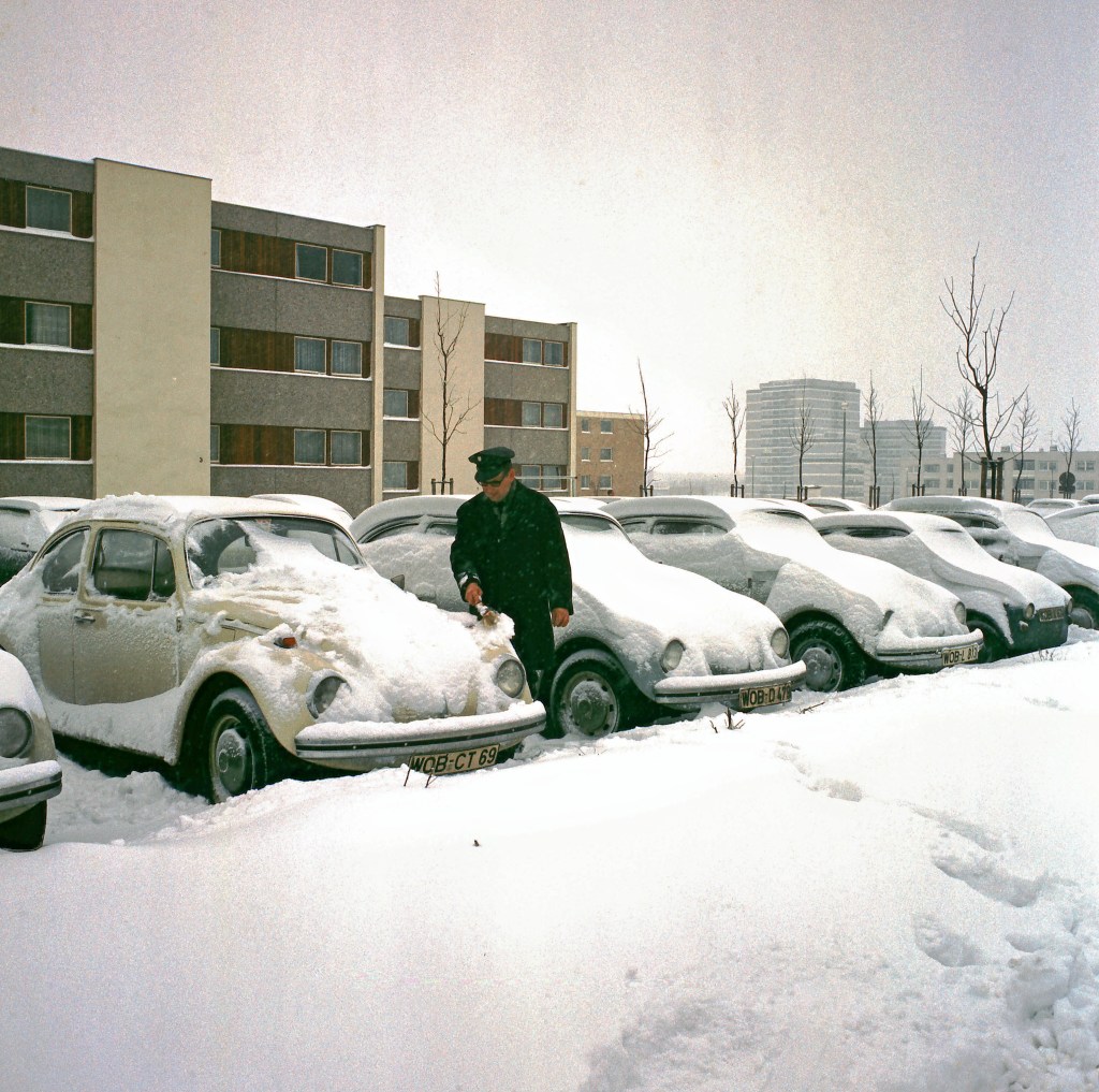german man looking at snowy cars