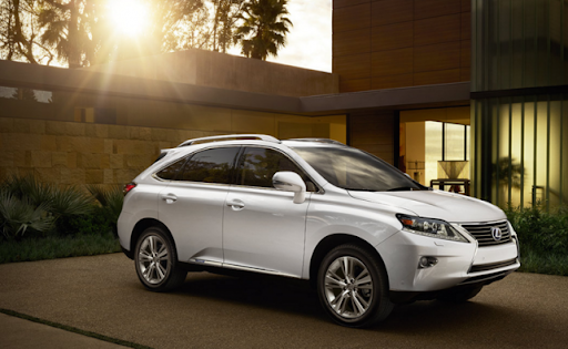 A white 2015 Lexus RX Hybrid parked in a sunny driveway.