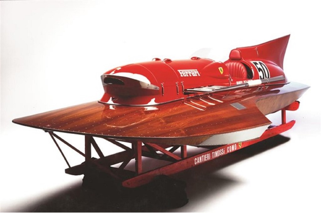 The red-and-mahogany 1952 Ferrari Arno XI hydroplane on its stand
