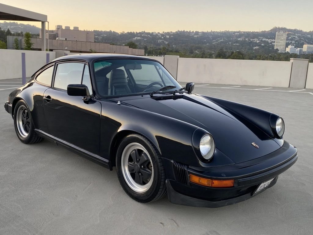 A black 1982 Porsche 911 SC on a parking garage roof