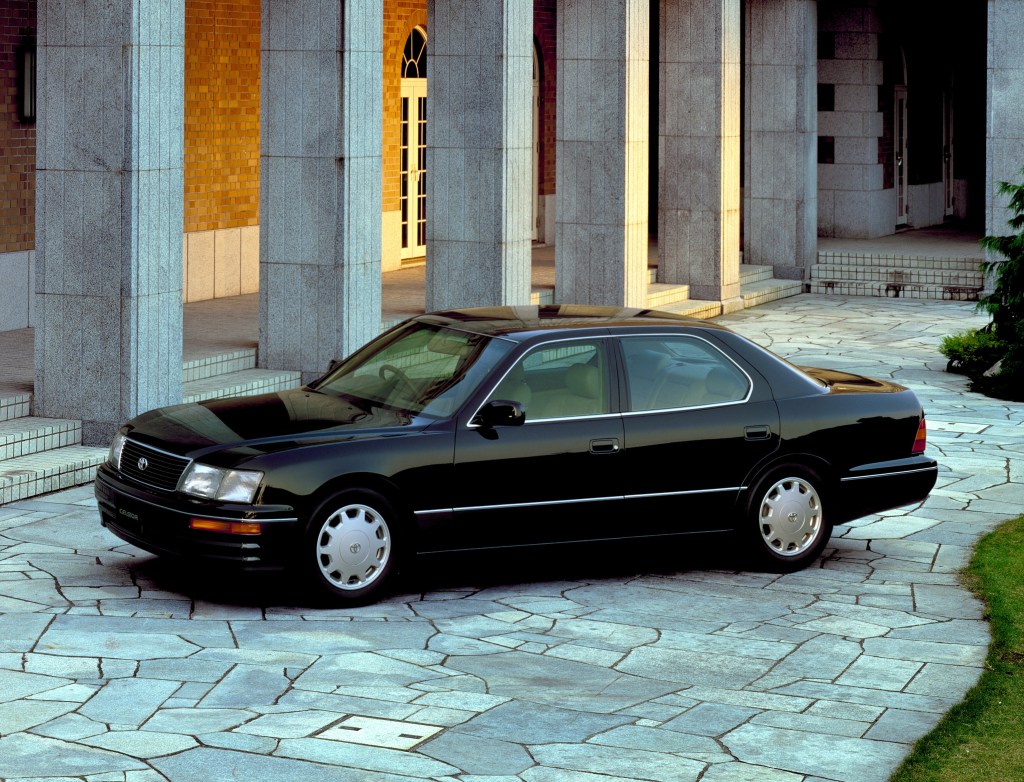 A black 1994 Toyota Celsior next to a regal building