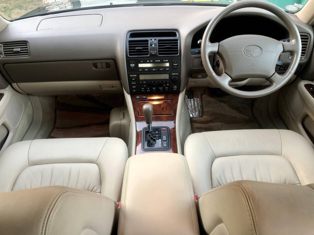 The tan-leather and wood-trimmed front interior of a 1995 Toyota Celsior