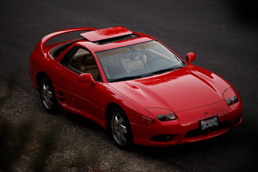 A red 1997 Mitsubishi 3000GT SL with its sunroof open