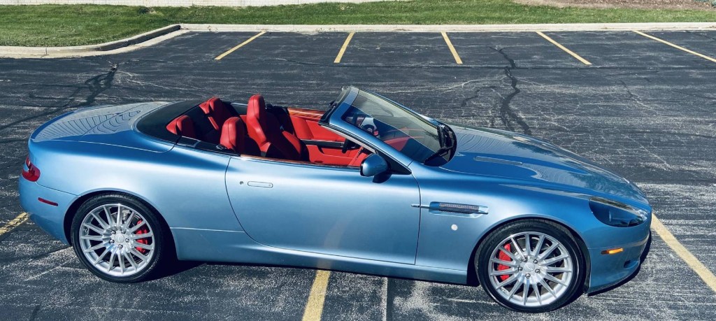 The side view of a blue 2006 Aston Martin DB9 Voltante with its top down