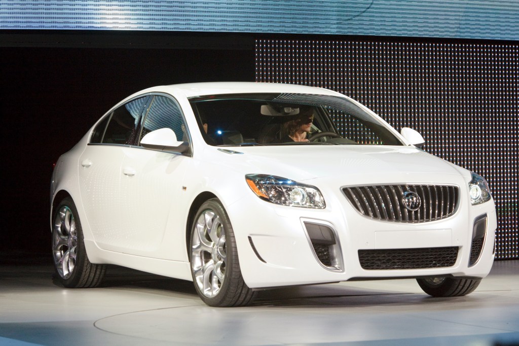woman drives 2012 Buick Regal on an auto show stage