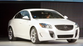 woman drives 2011 Buick Regal on an auto show stage