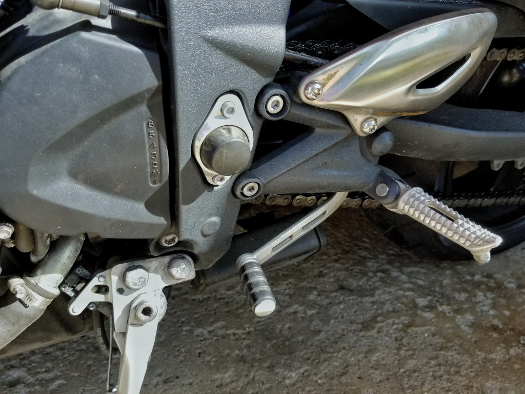 A close-up of the 2012 Triumph Street Triple R's toe shifter and transmission gear position diagram