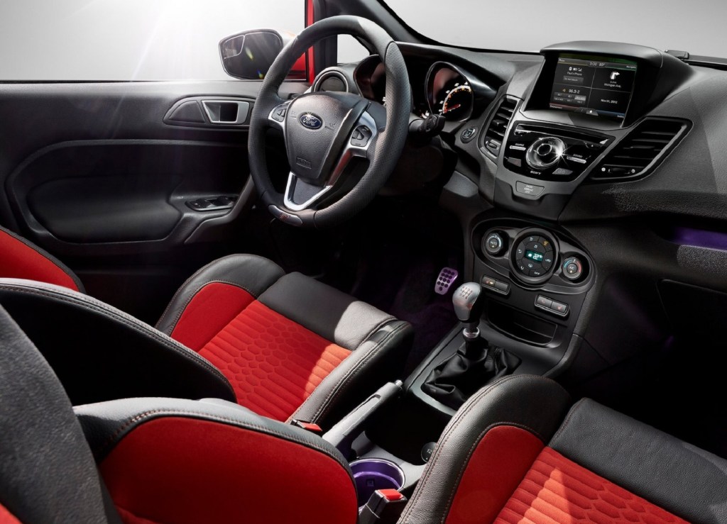 The orange Recaro front seats and black dashboard of a 2014 Ford Fiesta ST