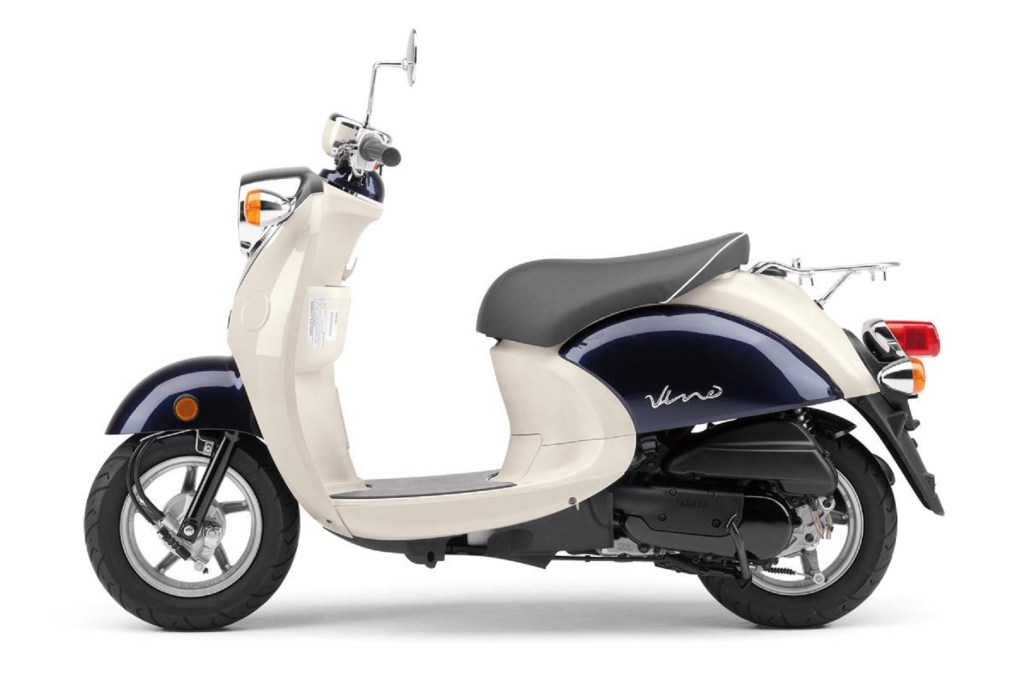 The side view of a tan-and-dark-blue 2017 Yamaha Vino 50 scooter