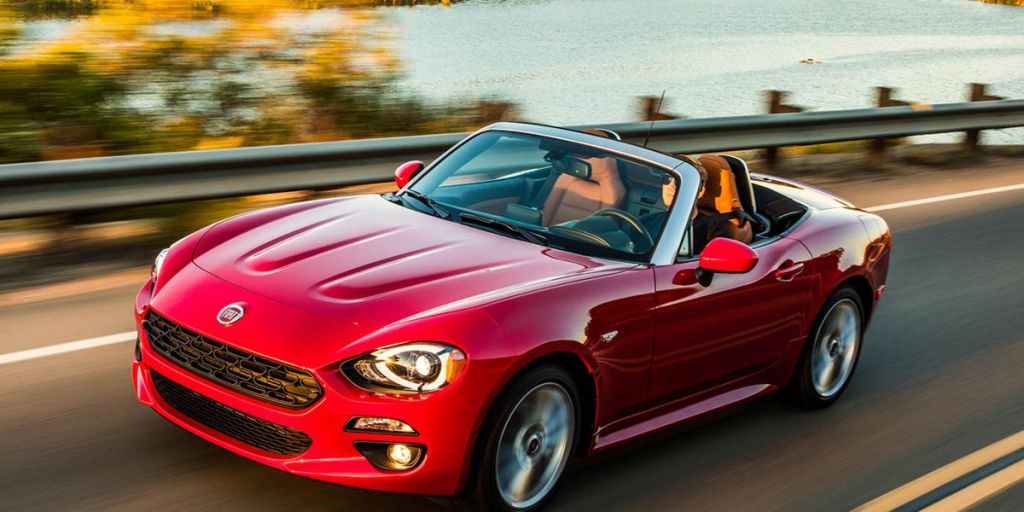 A red 2017 Fiat 124 spider with the top down on the highway.