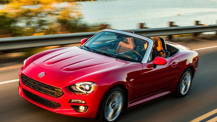 A red 2017 Fiat 124 spider with the top down on the highway.