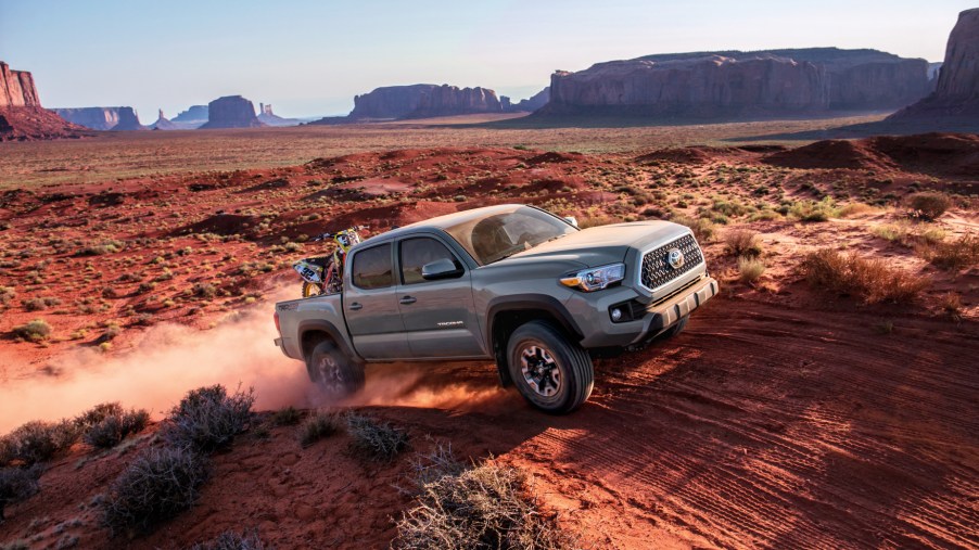 The 2018 Toyota Tacoma driving down a dirt road. Perfect used truck