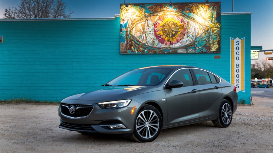A 2019 Buick Regal Sportback on display in front a blue wall with art hanging above it