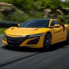 A yellow 2020 Acura NSX drives on a racetrack