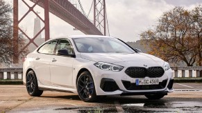 A white 2020 BMW M235i xDrive Gran Coupe in front of a bridge