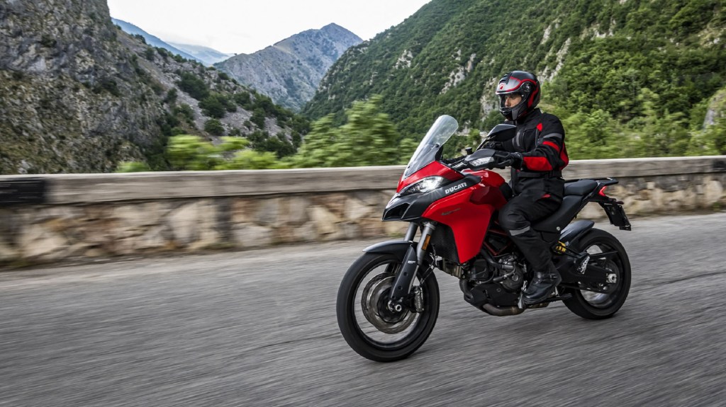 A rider on a red 2020 Ducati Multistrada 950 rides on a mountain road