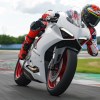 A red-clad rider takes a white 2020 Ducati Panigale V2 on a racetrack
