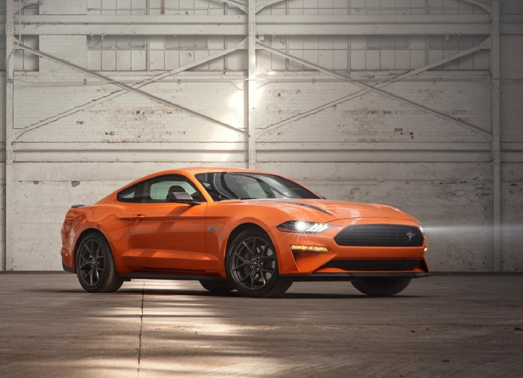 An orange 2020 Ford Mustang EcoBoost High Performance Package in a white-painted warehouse