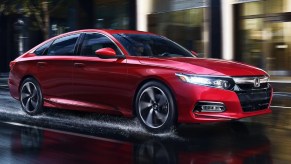 A red 2020 Honda Accord Sport 2.0T drives through a rain-soaked city