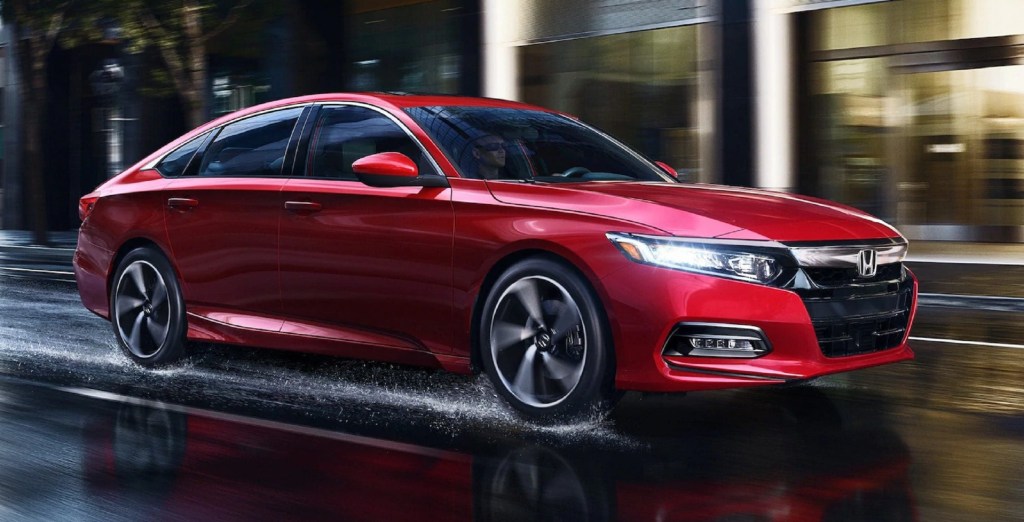 A red 2020 Honda Accord Sport 2.0T drives through a rainy city