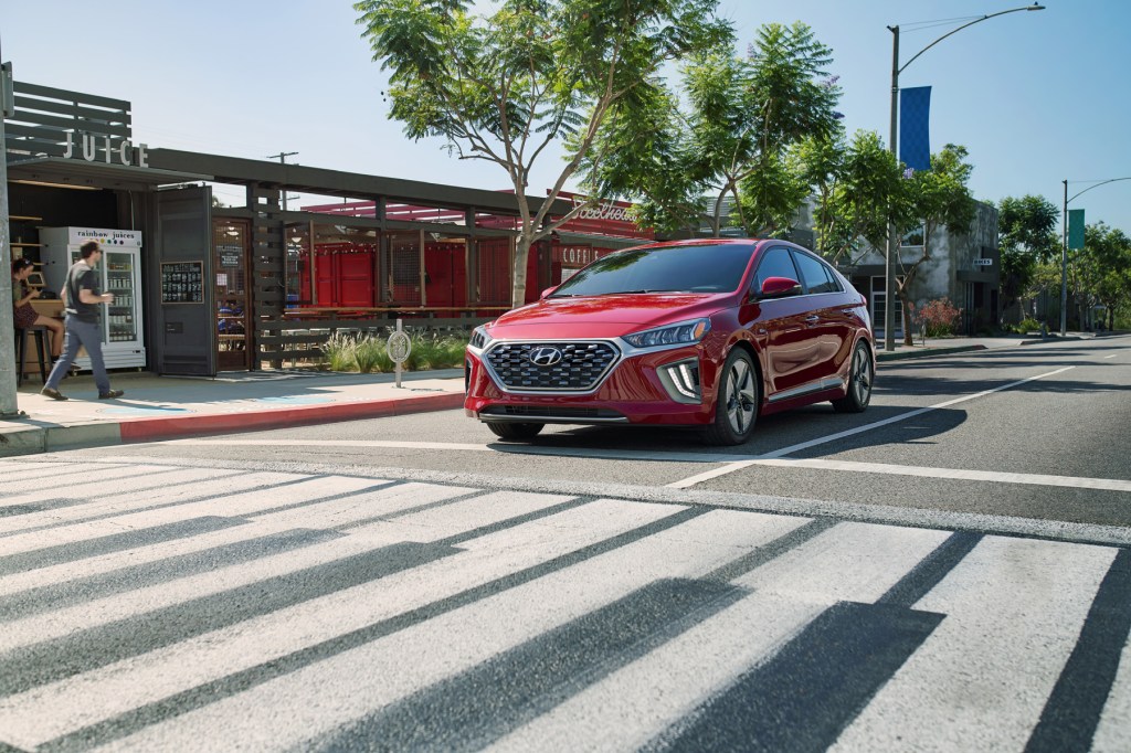 A red 2020 Hyundai Ioniq Hybrid shows off its commuter car capability while stopped at an intersection