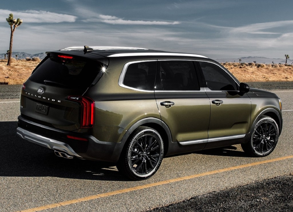 The rear 3/4 view of a green 2020 Kia Telluride on a desert road