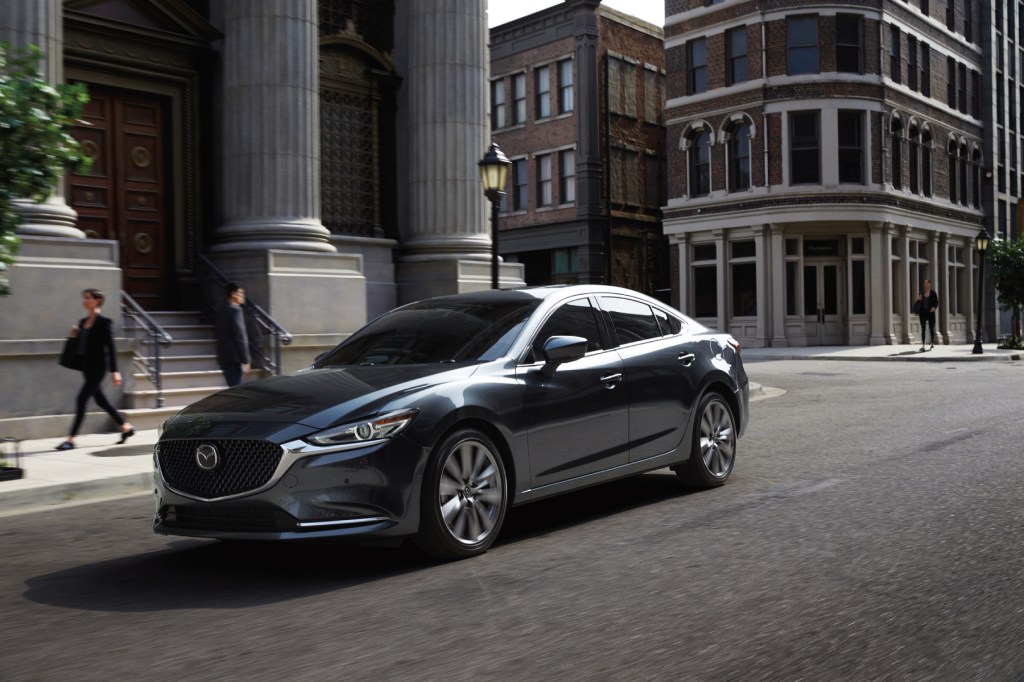 The 2020 Mazda6 driving down a city street with buildings in the background