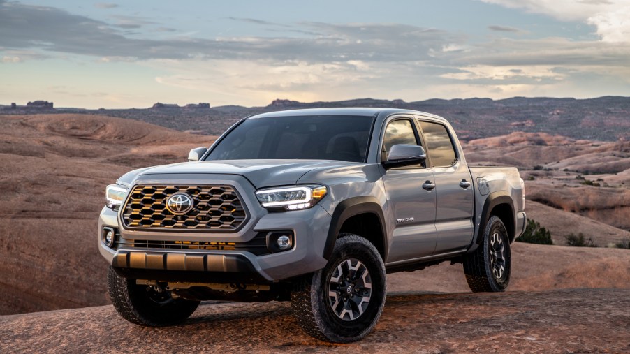 A silver 2020 Toyota Tacoma compact pickup truck parked on display
