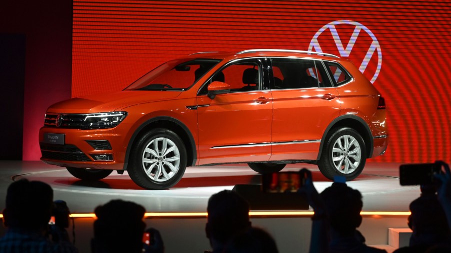 The 2020 Volkswagen Tiguan on display at an auto show with the VW logo in the background