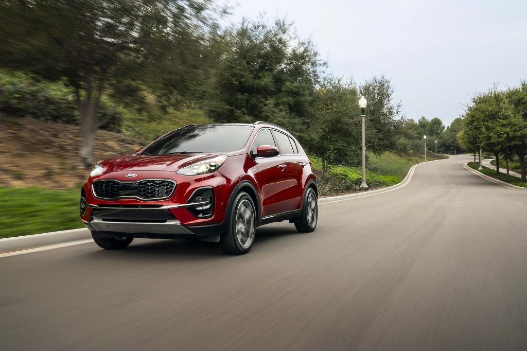 Red 2020 Kia Sportage driving on a road