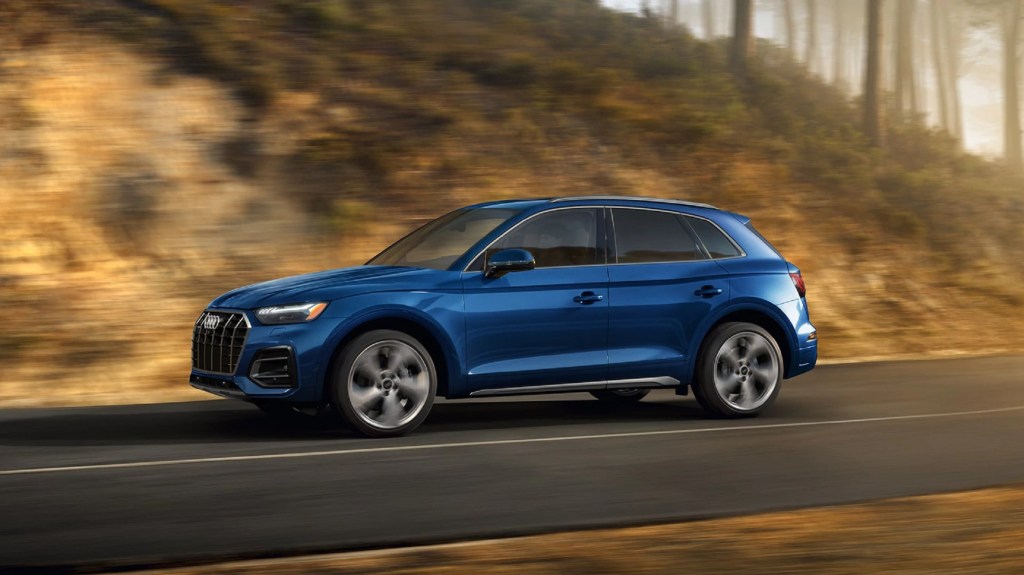 a blue Audi Q5 at speed on a scenic rural road