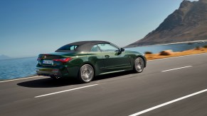 The 2021 BMW 4 Series Convertible driving on a road with an ocean view