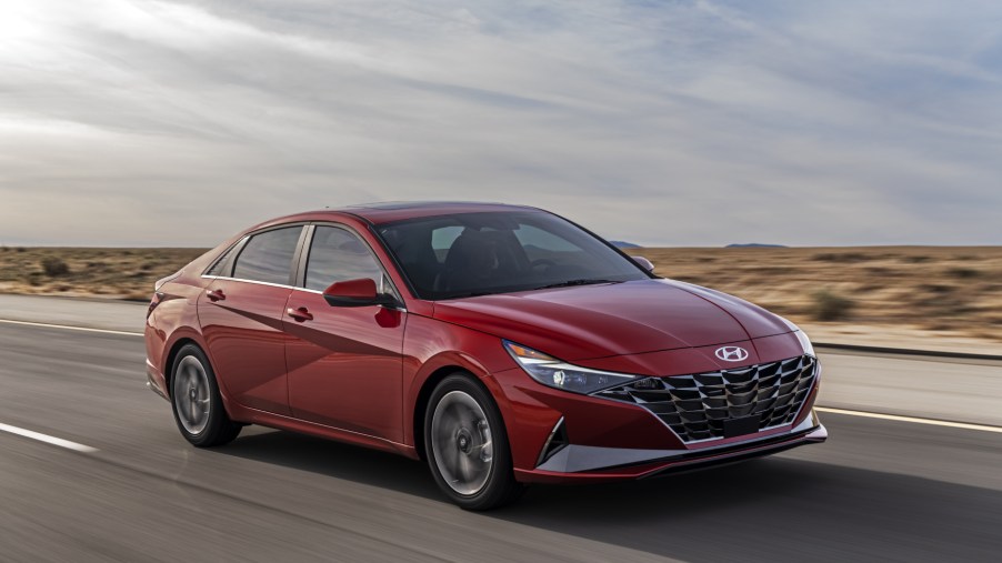 A red 2021 Hyundai Elantra driving on a highway