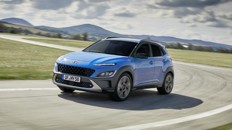 The 2022 Hyundai Kona driving around a curve of a road