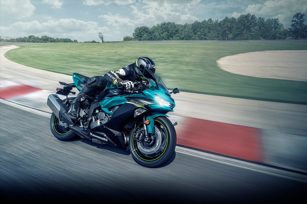 A rider takes a turquoise 2021 Kawasaki Ninja ZX-6R around a track