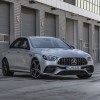 A press image of a silver 2021 Mercedes AMG E63 S sedan parked in front of an industrial building