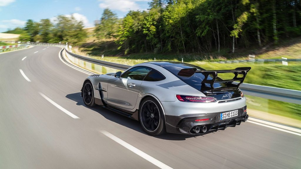The rear 3/4 view of a silver 2021 Mercedes-AMG GT Black Series driving on the road