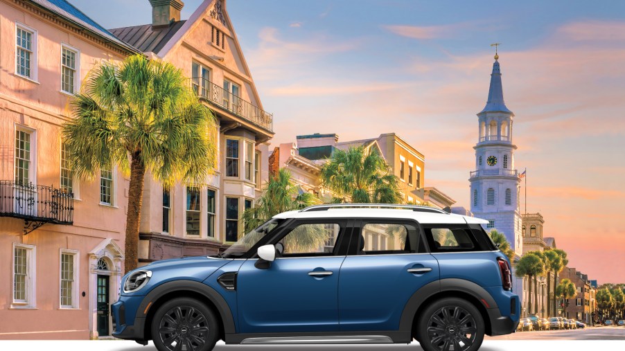 A blue 2021 Mini Countryman Oxford Edition on display with British scenery in the background.