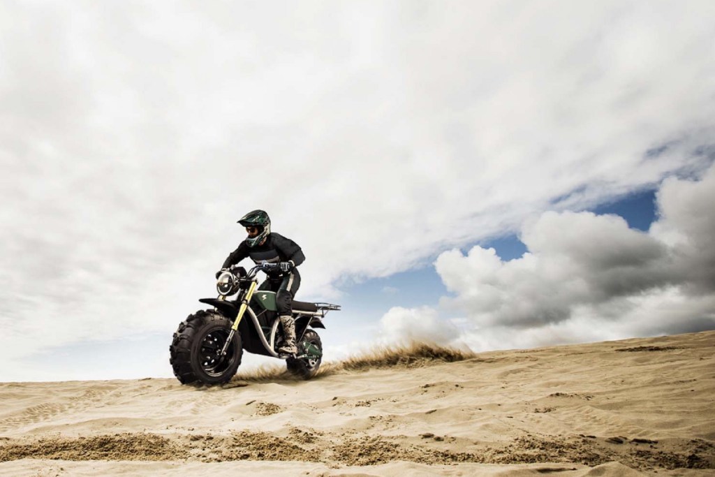 A rider tackles some dunes on a green 2021 Volcon Grunt