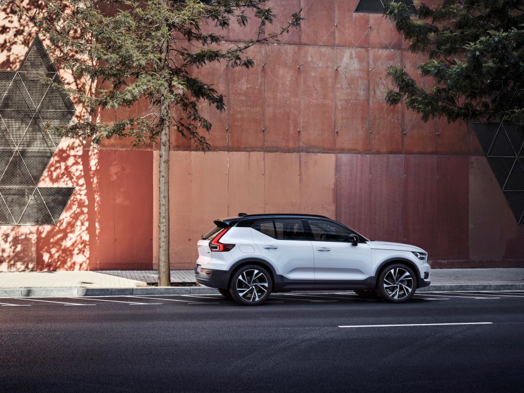 A white and black 2021 Volvo XC40 R-Design parked next to the side of a building