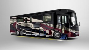 A Newmar Corp King Aire RV has all its storage compartment door open on the bottom of the bus.