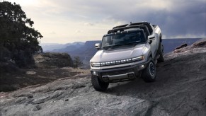 A silver 2022 GMC Hummer EV traversing rocky terrain