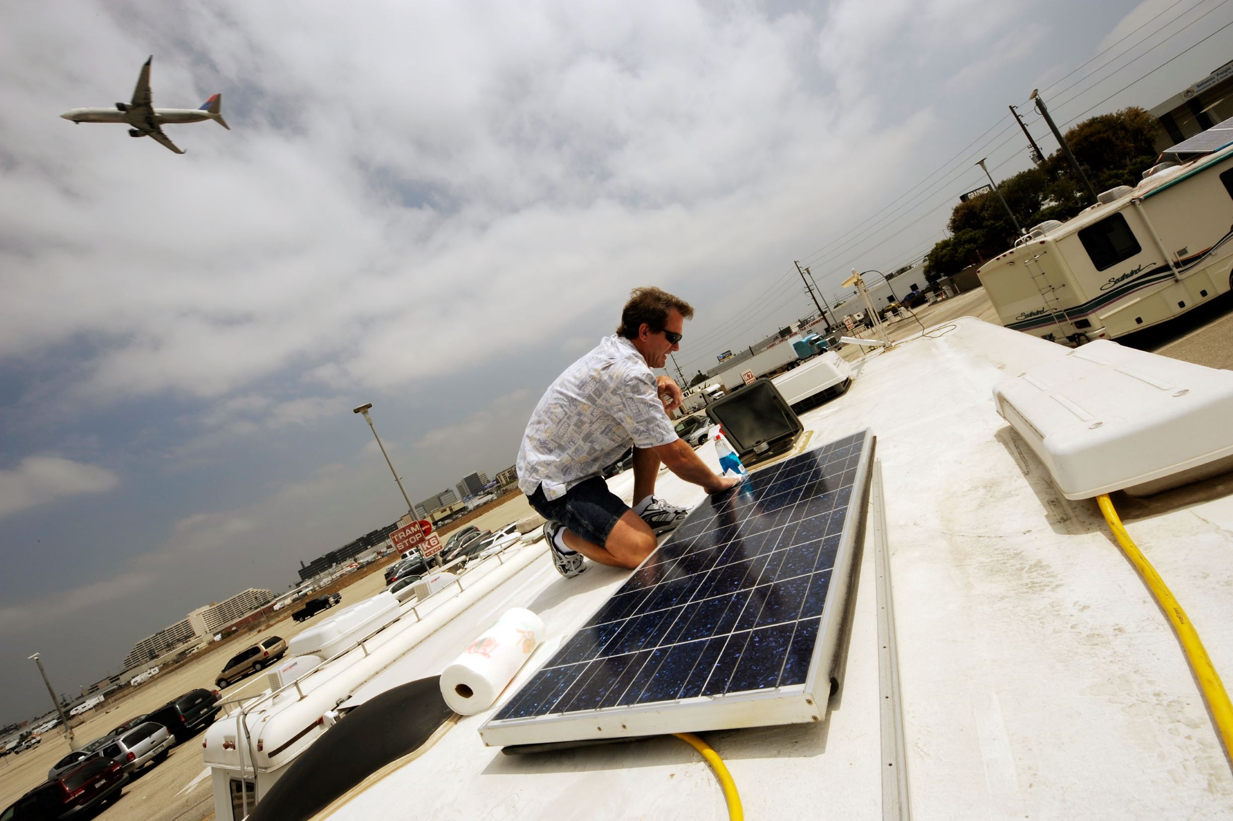 An aircraft mechanic does maintenance work on his RV's solar panels