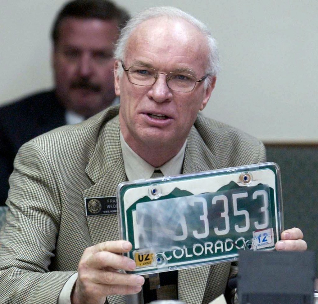 a man holding a covered-up license plate