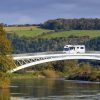 A camper van travels from the England to Wales over Bigsweir Bridge which spans the River Wye between Wales and England