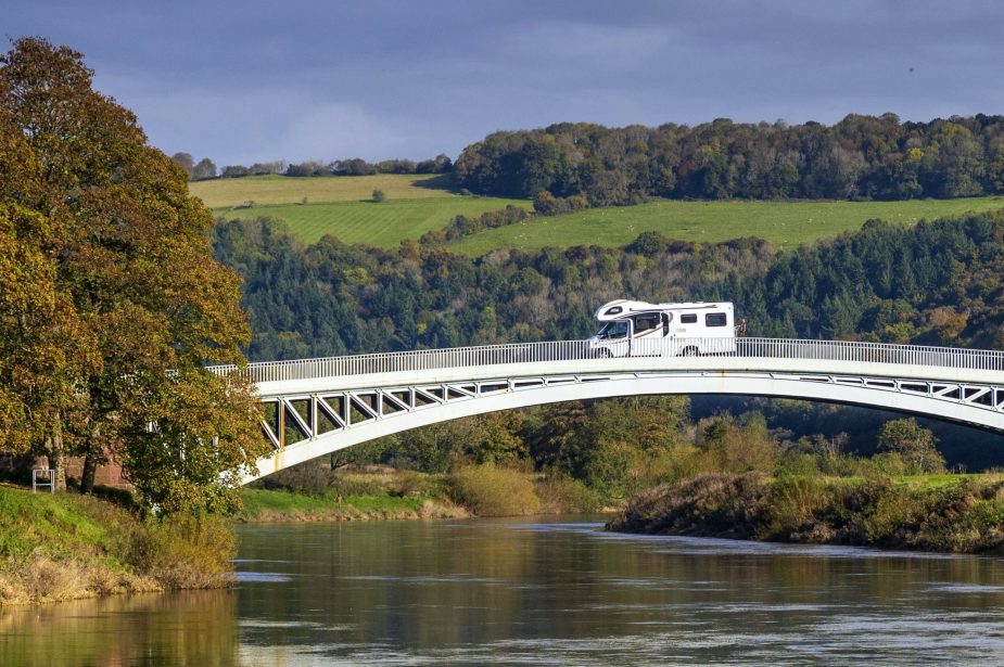 A camper van travels from the England to Wales over Bigsweir Bridge which spans the River Wye between Wales and England