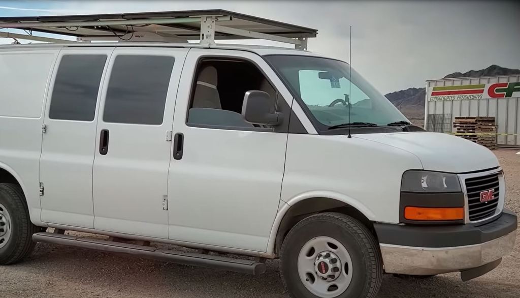 A white full-size van that has been converted into an RV.