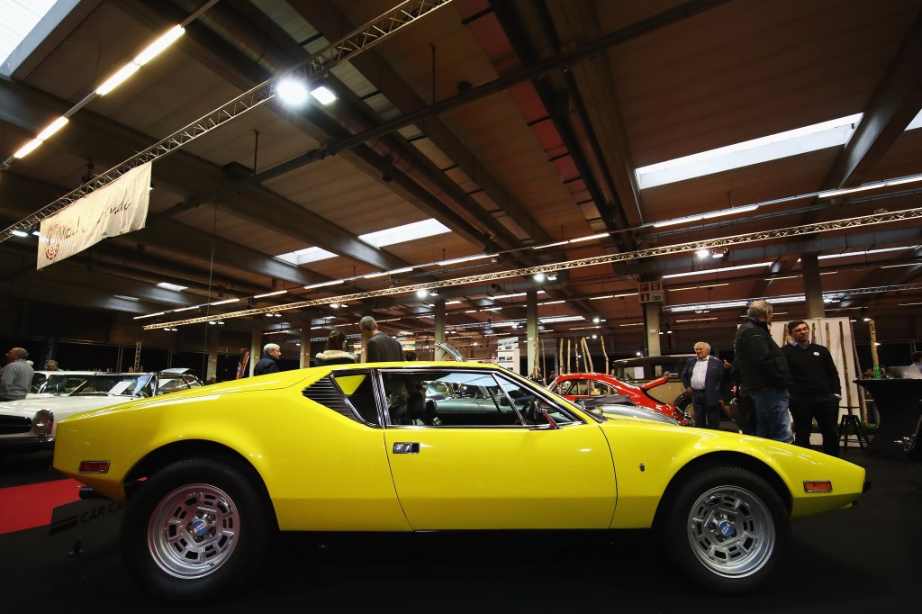 A yellow 1974 De Tomaso Pantera sits in an expo hall