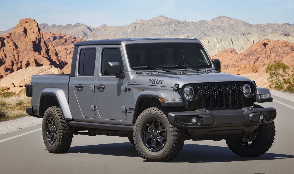 A Sting Gray 2021 Jeep Gladiator Willys in the middle of a road with a mountain backdrop